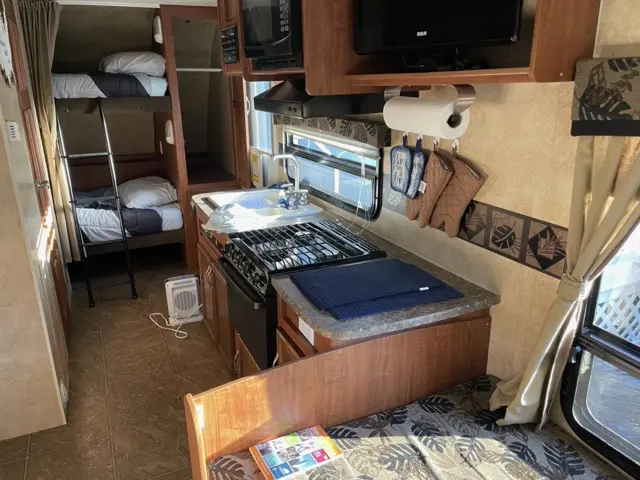 Stove and oven ready to explore of RV Rental trailer Blue Jay Getaway located at Kindlewood Camping in the Berkshires of Western Massachusetts