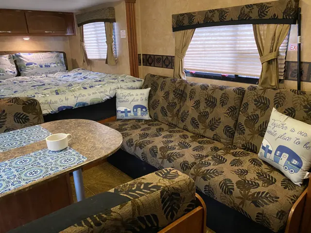 Comfy couch set up for you of RV Rental trailer Blue Jay Getaway located at Kindlewood Camping in the Berkshires of Western Massachusetts